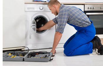 Специалист ремонтирует стиральную машину Indesit